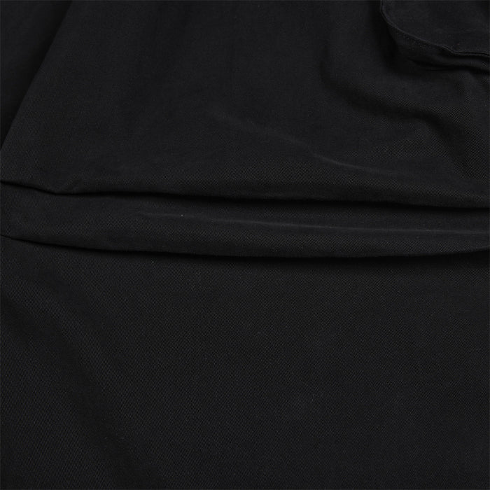 Detailed close-up of black cargo pant fabric and the stitched layered knee seam