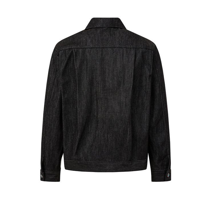 Back view of a black denim jacket with a pointed collar, long sleeves, seams, and buttoned cuffs