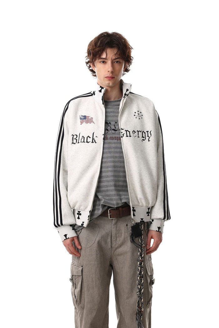 Model wearing a light gray full-zip track jacket with black sleeve stripes and front graphic