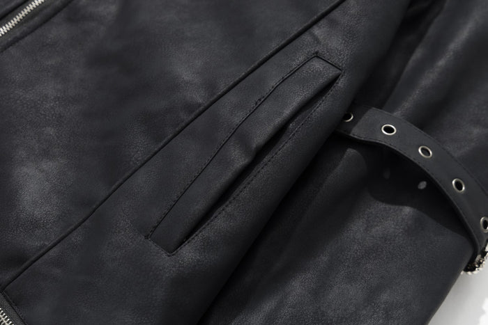 Close-up of the black jacket sleeve showing a vertical pocket detail and an adjustable eyelet buckle strap