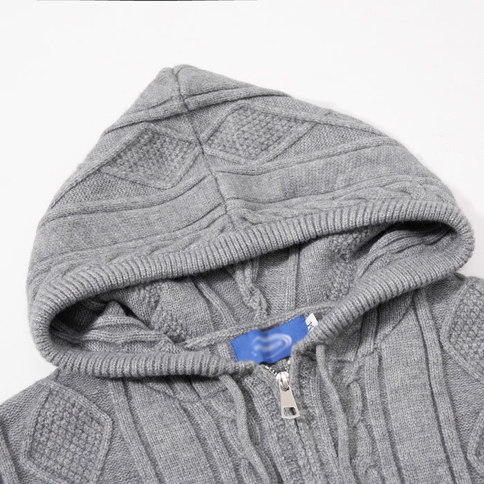 Close-up of the gray knit hoodie showing the drawstring hood, zipper top and textured diamond pattern