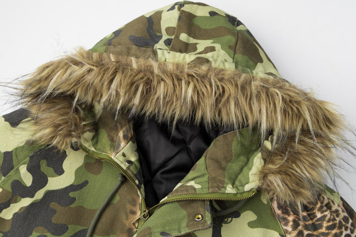 Close-up of the raised camouflage hood showing its tan faux-fur trim, black lining, and front zipper