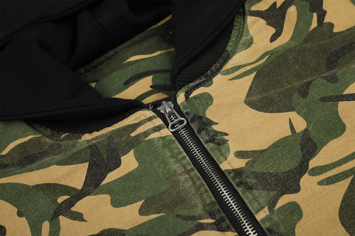 Close-up of the black front zipper and pull beneath the bomber jacket's black hood