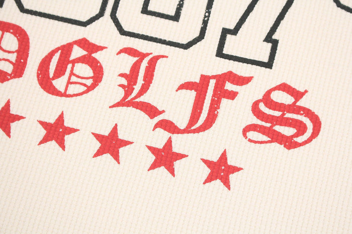 Close-up of red lettering and a row of stars on the cream waffle-knit shirt front
