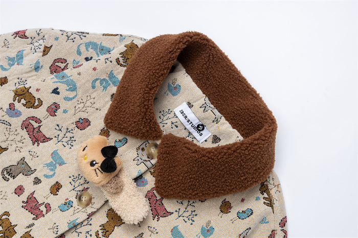 Close-up of the beige jacket’s brown fleece collar and attached plush bear clasp over the cat-print fabric