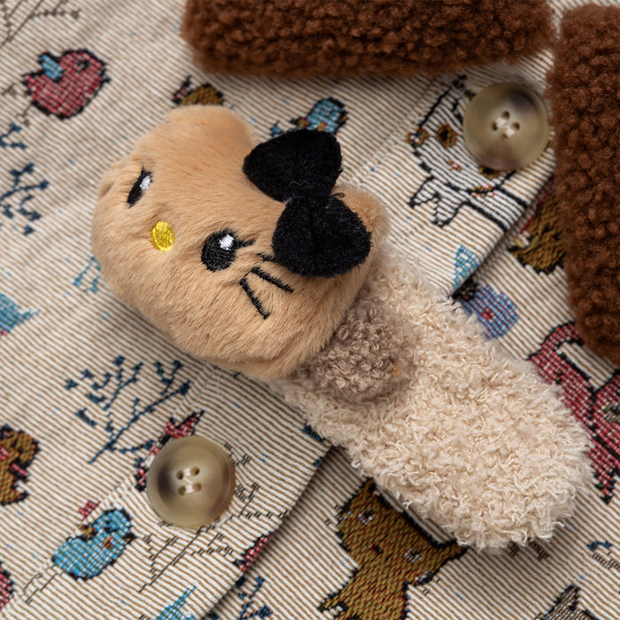 Detailed view of the plush bear clasp, beige buttons and colorful cat print on the jacket front