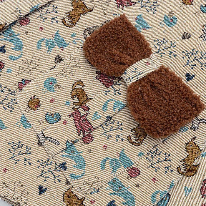 Close-up of the jacket’s brown fuzzy front pocket accents against beige fabric with a colorful cat print