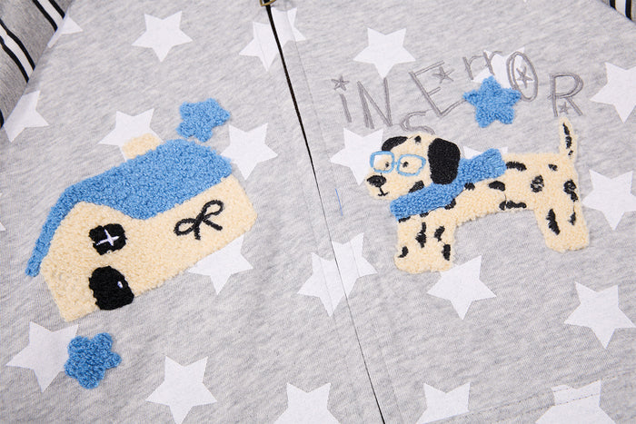 Close-up of embroidered blue and cream cartoon-style graphics on the gray star-print hoodie front