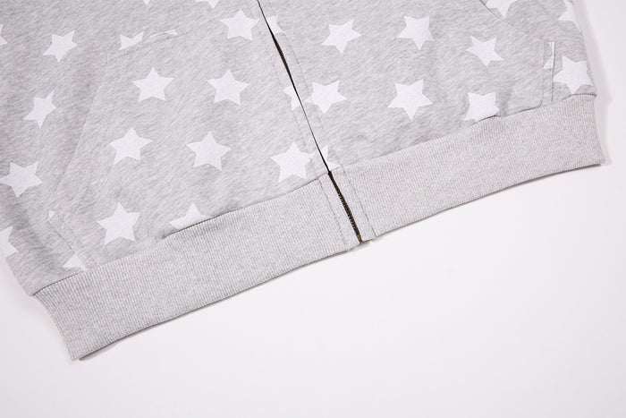 Close-up of the hoodie’s gray ribbed bottom hem and centered metal zipper end