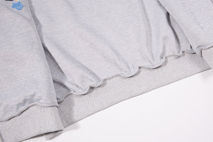Inside view of the hoodie showing the gray fabric, ribbed hem, and finished interior seam edges