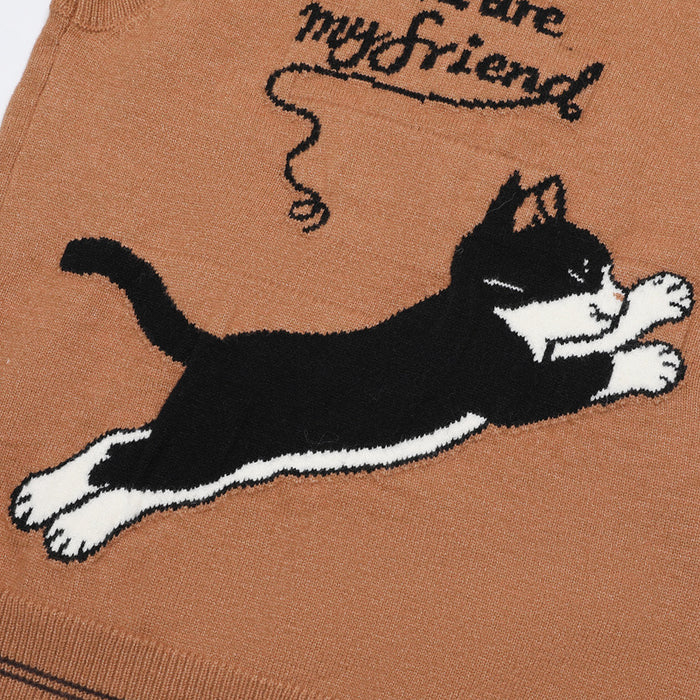 Close-up of the vest back showing a leaping black-and-white cat graphic with friendship text on brown knit fabric