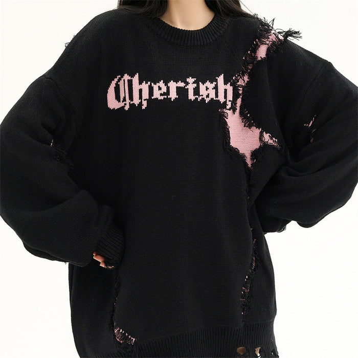 Front view of a black oversized sweater with pink distressed knit patches, ribbed cuffs and crew neckline