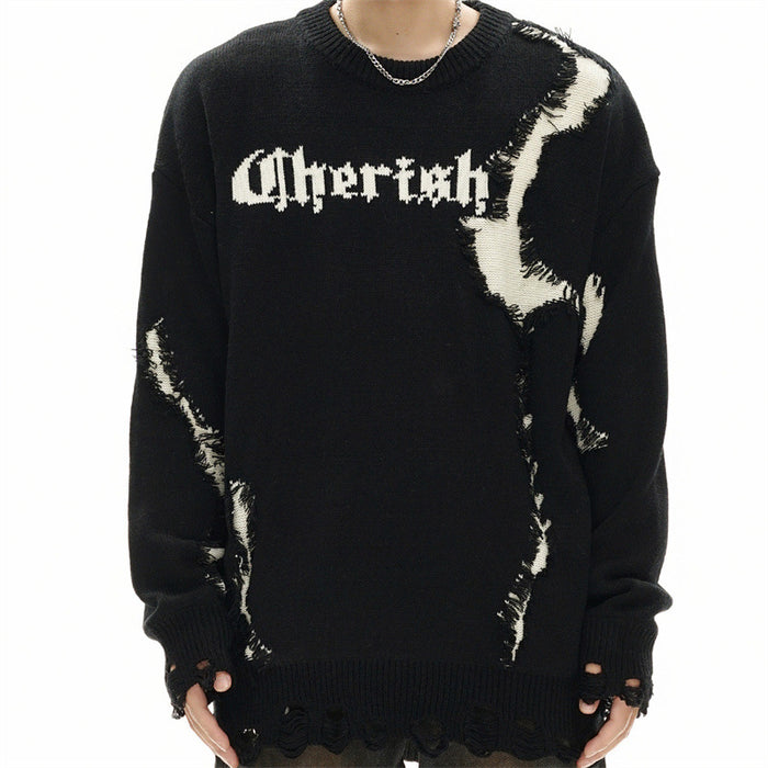 Model wearing a black distressed sweater with white abstract patches, chest lettering and cutout cuffs