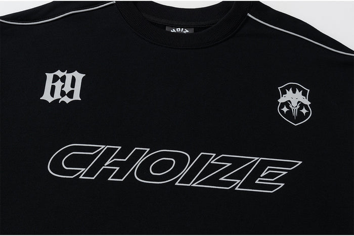 Close-up of black sweatshirt chest showing outlined Choize graphic, two white emblems, and shoulder piping