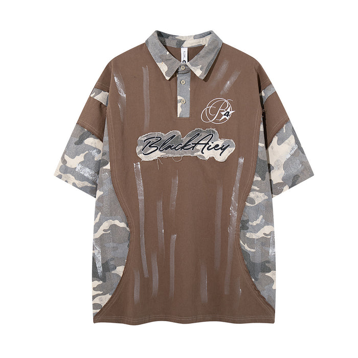 Front view of brown polo shirt with gray camouflage sleeves, striped paint marks, collar, and script chest patch