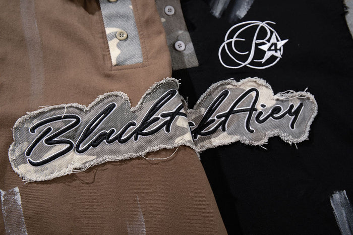 Close-up of script fabric chest patches and circular logo details on brown and black polo shirts