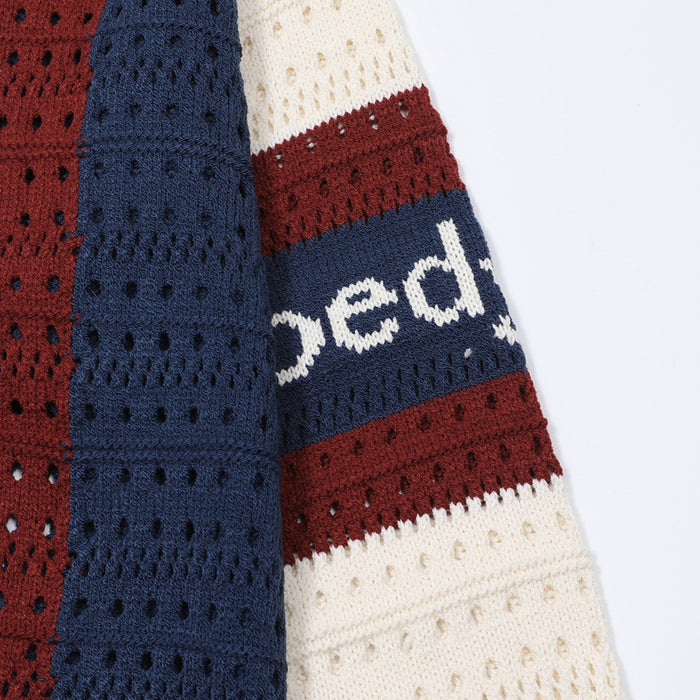 Close-up of the cream, burgundy, and navy striped sleeve with partial white lettering and open-knit texture