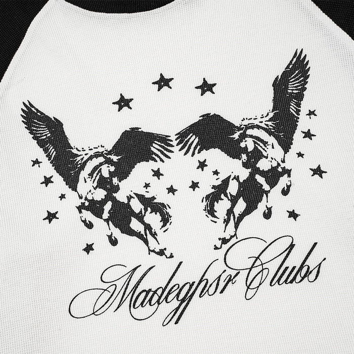 Close-up of the tee’s black winged horse graphic, scattered stars, and flowing script on white fabric