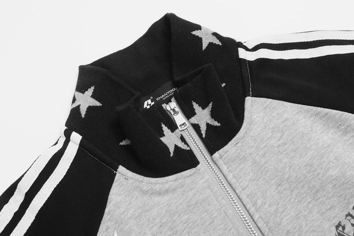 Close-up of the jacket's star-print black collar, silver zipper, and white sleeve stripe