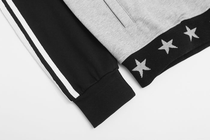 Close-up of the black sleeve cuff and gray hem featuring white stripes and star-patterned trim
