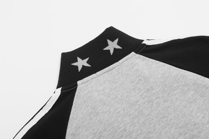 Close-up of the black jacket collar with white stars beside the gray body and raglan sleeve seam