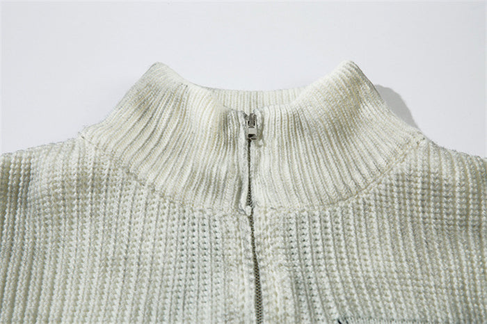 Close-up of the cream cardigan's ribbed high collar and metal zipper at the neckline