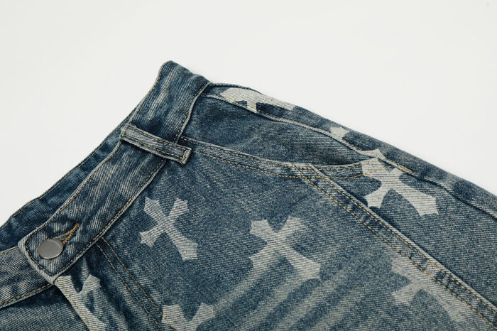 Close-up of the blue jeans waistband showing belt loops, button fastening, stitching, and cross prints