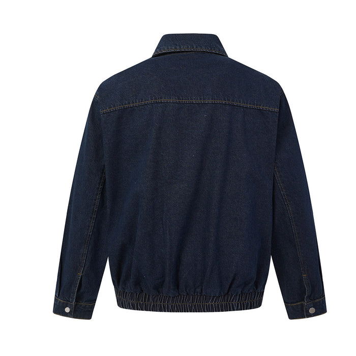 Back view of a dark indigo denim bomber jacket showing the yoke seam, long sleeves and gathered elastic hem