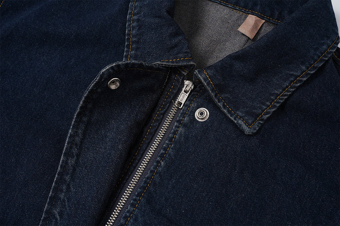 Close-up of the denim bomber jacket collar and front zipper with visible snap fastening and contrast stitching