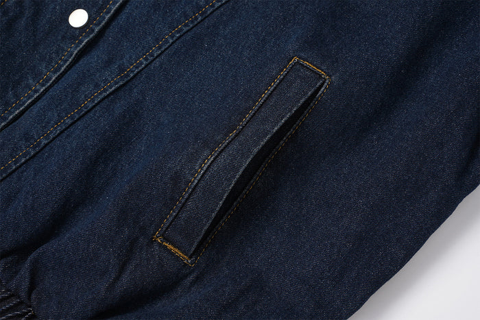 Close-up of a vertical welt hand pocket on the dark indigo denim jacket front