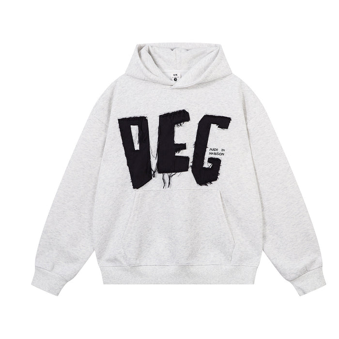 Light gray oversized hoodie front with black frayed DEG appliqué lettering and a kangaroo pocket
