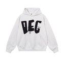 Light gray oversized hoodie front with black frayed DEG appliqué lettering and a kangaroo pocket