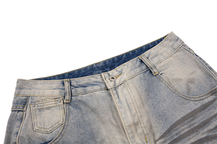 Close-up of washed blue jeans waistband showing belt loops, button closure, front pocket and curved stitching