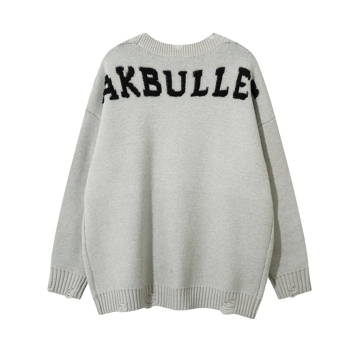 Light gray oversized knit sweater back with bold black lettering across the upper shoulders
