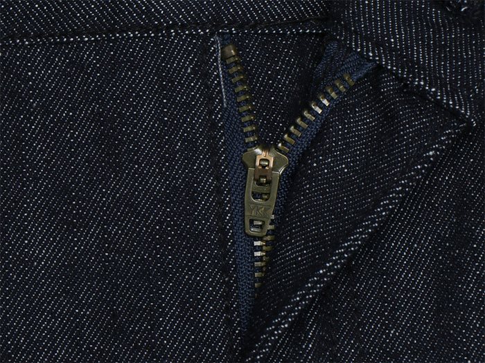 Close-up of the dark denim zipper fly showing the metal slider, teeth, and diagonal twill texture