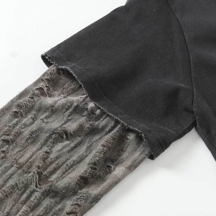 Close-up of the raw-edged black short sleeve layered over a distressed patterned long sleeve