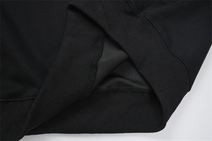Close-up of black hoodie ribbed edging and overlapping fabric at the hem or cuff construction