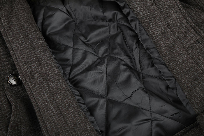 Open jacket detail showing black quilted padding inside the dark brown outer shell