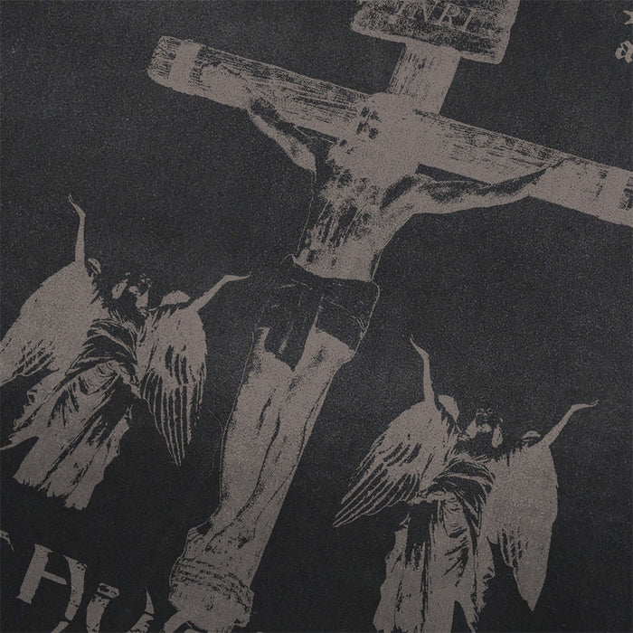 Close-up of the distressed crucifix and winged figure graphic printed across the black tee front