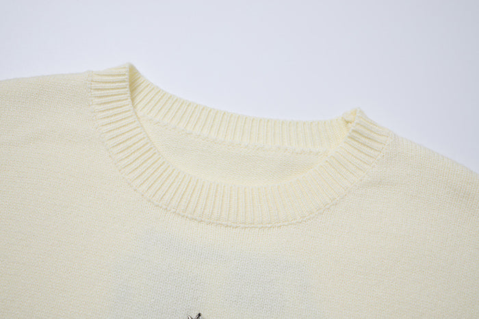 Close-up of the cream sweater's ribbed knitted crew neckline