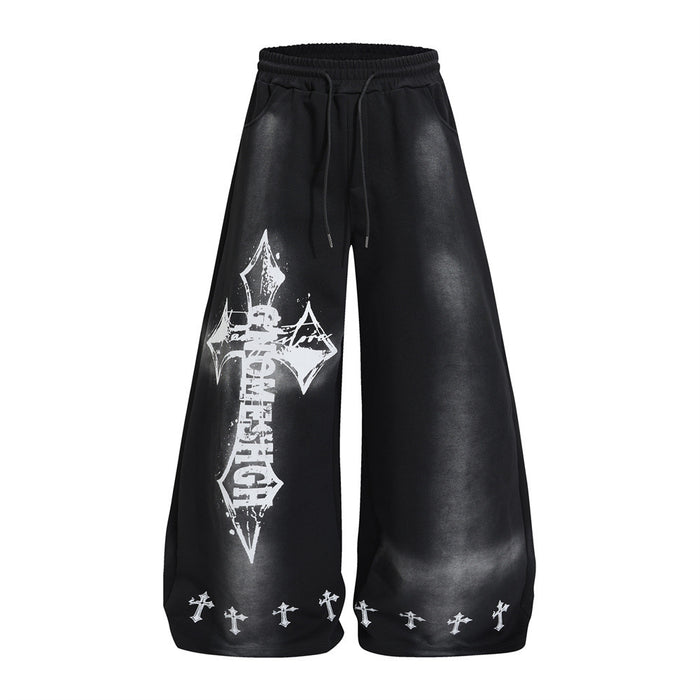 Front view of black wide-leg sweatpants with a large distressed white cross graphic and small crosses along the hems