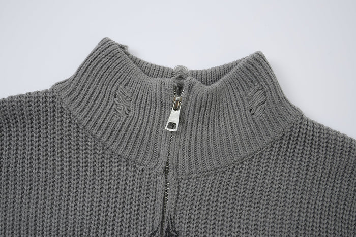 Close-up of the gray sweater’s ribbed turtleneck collar, metal zipper, and textured knit stitching
