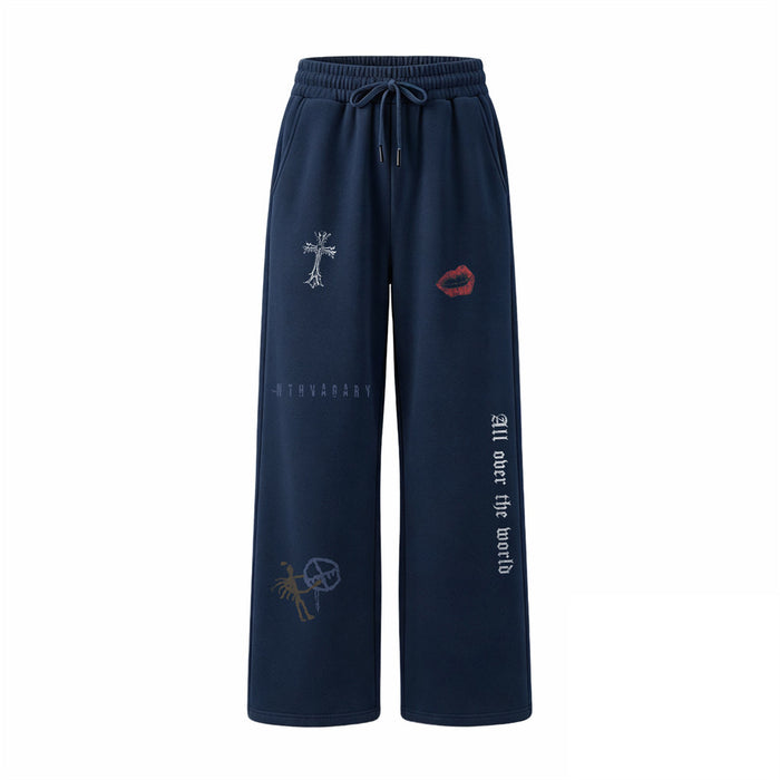Front view of navy wide-leg sweatpants with cross, lips, text, and illustrated lower-leg graphics