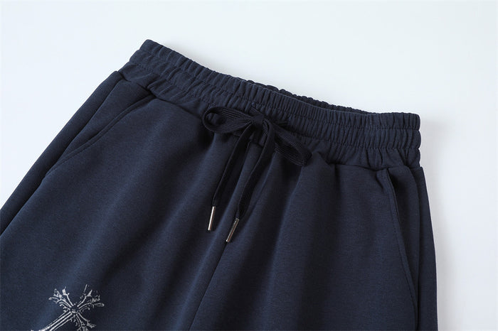 Close-up of navy sweatpants waistband, drawstring, front pocket opening, and partial graphic print