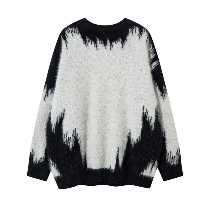 Back view of a white and black fuzzy knit sweater with a jagged gradient pattern and ribbed cuffs
