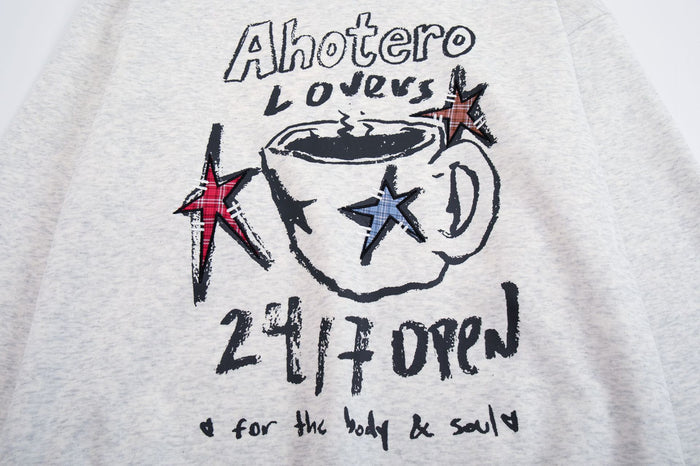 Close-up of the light gray hoodie chest graphic with a coffee cup, red and blue stars, and lettering