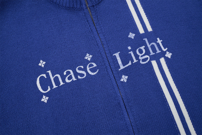 Close-up of blue knit fabric with white Chase Light lettering, small decorative symbols, and vertical stripes