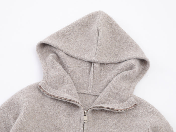 Close-up of the light beige knit hoodie hood, inner seam, and partially opened metal zipper