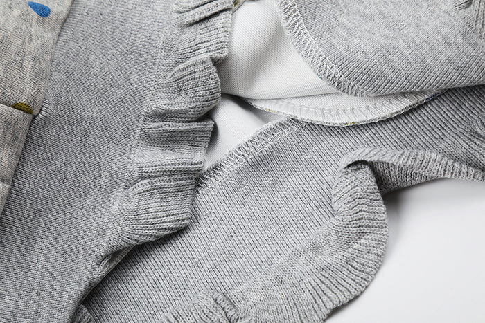 Interior close-up of the grey hoodie showing overlocked seams, soft fabric, and ribbed ruffled hem detail