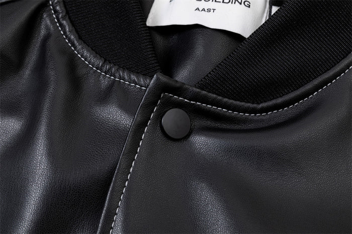 Close-up of a black PU bomber jacket collar showing ribbed trim, white stitching and a black snap